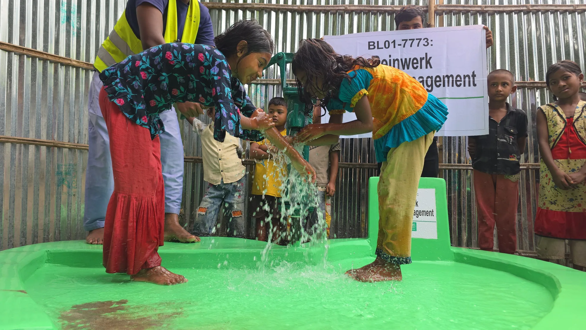 Kinder und Erwachsene nutzen den von Reinwerk Gebäudemanagement unterstützten Brunnen in Bangladesch