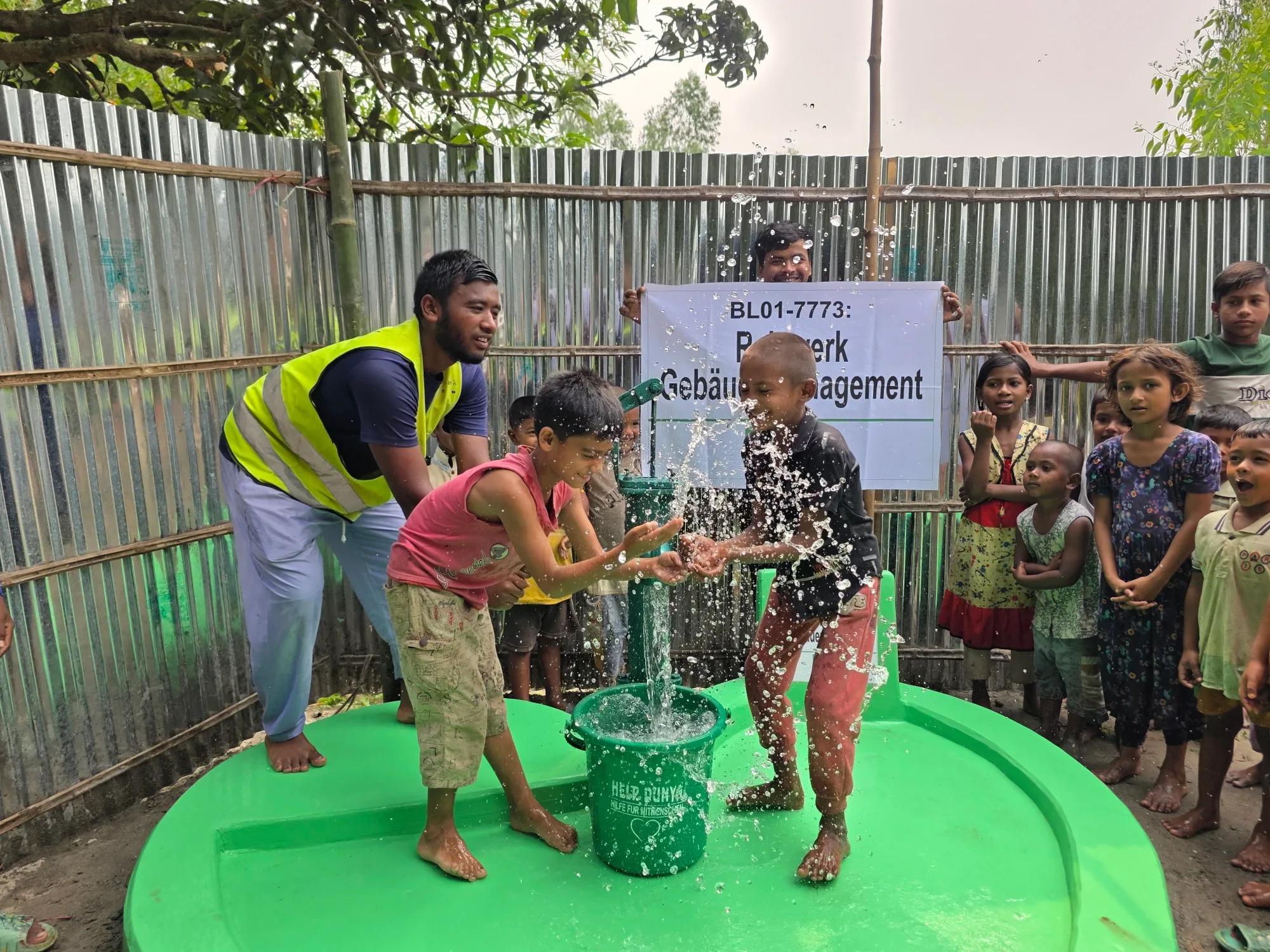 Kinder nutzen den neuen Brunnen in Bangladesch