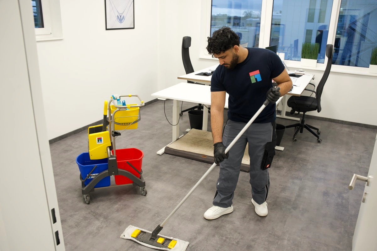 Reinwerk Mitarbeiter bei der professionellen Bodenreinigung in einem Büro